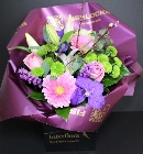 Hand tied pink roses, pink Gerbera, stargazer lily, green santini chrysanthemum, purple Lissianthus, Vanda Orchid & pussy willow bound with selective foliage.
